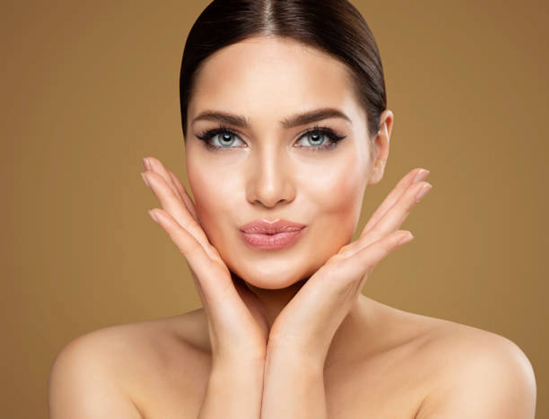 Woman with smooth, radiant skin framing her face with her hands